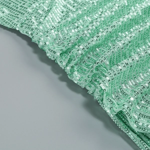 Close-up of shimmering mint green sequins on halter neck evening gown fabric