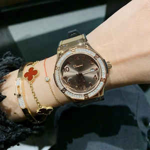 Women's gold watch with black silicone strap and crystal bezel featuring date function