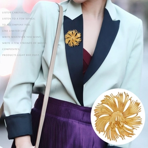 Detailed macro view of a vintage golden floral brooch with intricate fringe textures