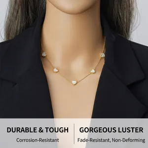 Model wearing gold heart pendant necklace with mother of pearl inlays on a black blazer