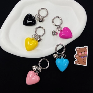 Colorful heart resin keychains in black, pink, blue, yellow on white display tray