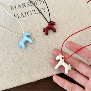 Detailed macro view of three colorful enamel horse pendants in white, blue and red