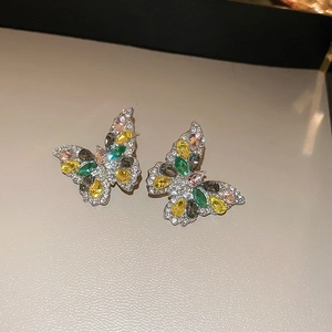 Macro shot of silver butterfly stud earrings featuring colorful crystals and white rhinestones