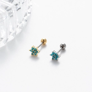 Detailed macro view of gold and silver steel cartilage studs with blue turquoise stars