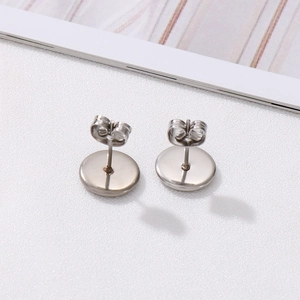 Minimalist silver stainless steel round stud earrings with butterfly backs on white background