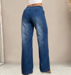 Detail van elastische taille met trekkoord op blauwe wijde jeans met vintage waseffect