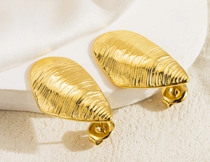 Macro shot of gold-plated teardrop earrings with elegant horizontal pleated textures