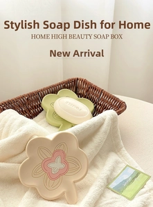 Detail of flower shaped silicone soap dishes in green and beige on soft towels