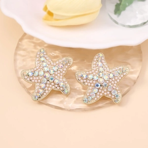 Détail de boucles d'oreilles étoile de mer avec micro-perles et cristaux scintillants