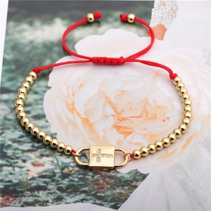 Adjustable red rope bracelet with gold beads and a sparkling zircon cross lock charm