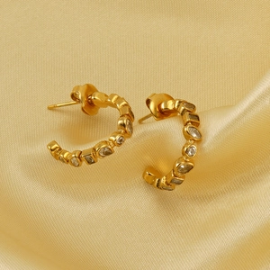 U-shaped 18k gold earrings with geometric cubic zirconia stones on yellow silk