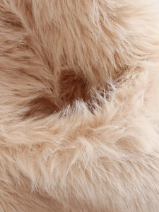 Vue macro de la texture de fausse fourrure avec fibres beige doré pour gilet d'automne