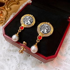 Detail of vintage portrait earrings with red gems and pearls in a velvet box