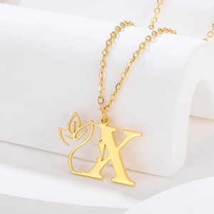 Close-up of golden letter A pendant with floral hollow design on a white geometry stand