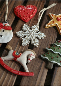 Close-up of resin Christmas ornaments featuring gingerbread-style stars and trees