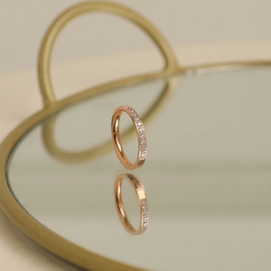 Close-up of 18k rose gold ring featuring detailed micro-pave setting with ten small diamonds