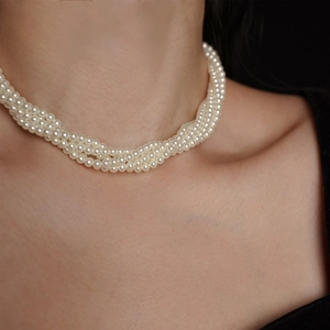 Dettaglio dell'elegante collana di perle bianche a tre fili indossata per un'occasione