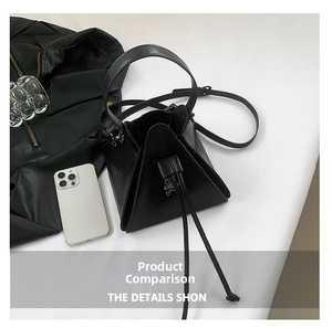 Overhead view of a black geometric triangle crossbody bag with drawstring closure