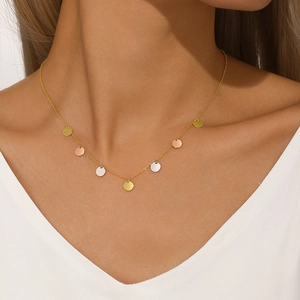 Close-up of tricolor gold, silver and rose gold disc charms on a delicate S925 silver chain