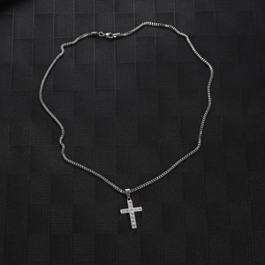 Hip hop silver cross pendant necklace with sparkling diamonds on a black textured background