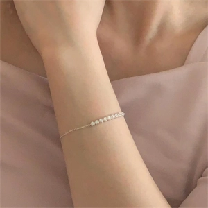 Detailed view of silver S925 bracelet with seven sparkling zircons on a woman's wrist