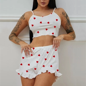 White two-piece loungewear set with red heart print featuring crop top and ruffled shorts