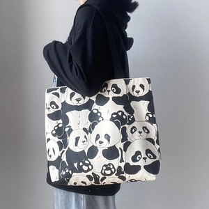 Detail shot of a large canvas tote bag with panda print showing its size and capacity
