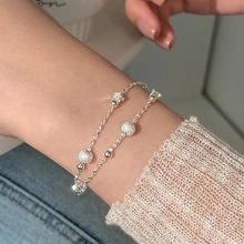 Detail of double-layer silver star bracelet with moonstone beads on a female wrist