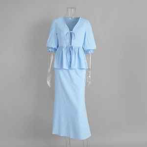 Detail of light blue two-piece set featuring V-neck tie-front top and ruffle sleeves