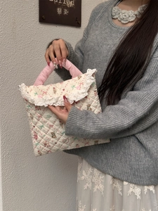 Detailed shot of quilted laptop bag with lace trim and cute cartoon prints