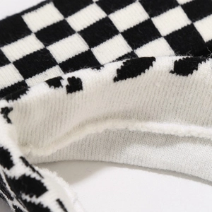 Macro shot of black and white checkered knit headband showing detailed stitching and texture