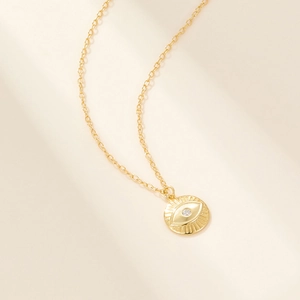 Close-up of golden S925 silver necklace with a sparkling diamond-set evil eye pendant