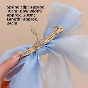 Macro detail of 20cm light blue organza bow clip with 10cm gold metal spring fastener