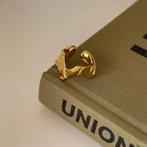 Detailed view of an irregular textured gold ring resting on a vintage book corner