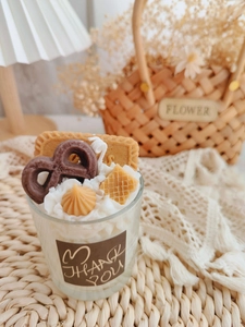 Macro detail of soy wax scented candle with realistic biscuit toppings in a glass cup