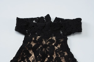 Close-up of black floral lace detailing with intricate embroidery on the dress shoulder
