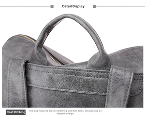 Detailed macro view of vintage grey leather backpack with precise stitching and reinforced handle