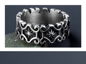 Macro detail of gothic titanium steel ring with sun star relief and brushed metal texture