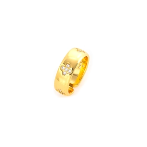 Detailed close-up of golden four-leaf clover ring with sparkling embedded crystals