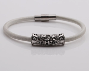 Close-up of white braided bracelet with silver metal cylinder and magnetic clasp