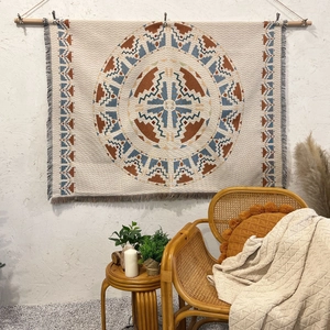 Detail einer Boho-Webdecke mit geometrischen Mandala-Mustern und Fransenrand