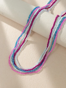Close-up of multi-layered bohemian waist chain with colorful beads on a stand