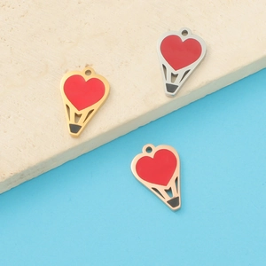 Detailed view of red enamel heart-shaped hot air balloon pendants in gold and silver