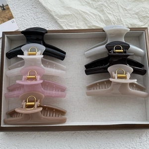 Detailed collection of 8 curved PC hair claw clips in assorted colors on wooden tray