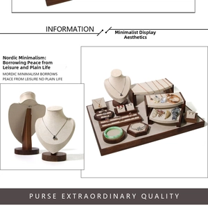 Detail of walnut wood jewelry display set with beige linen necklaces and ring holders
