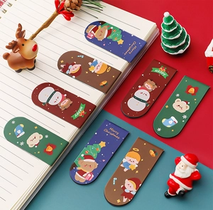 Close-up of colorful Christmas magnetic bookmarks with cartoon motifs in a notebook