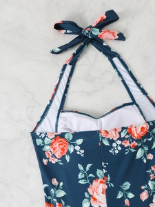 Detailed view of dark blue floral halter neck swimsuit with pink rose print and bow tie