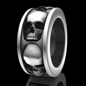 Detailed close-up of a silver gothic skull ring with mechanical punk carvings and reflections