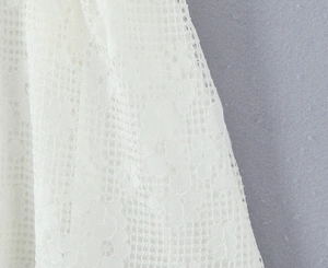 Vue macro détaillée de la dentelle florale blanche et de la texture en maille sur la robe