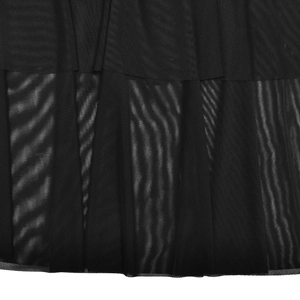 Détail de robe noire avec ourlet en mesh semi-transparent et finitions de couture
